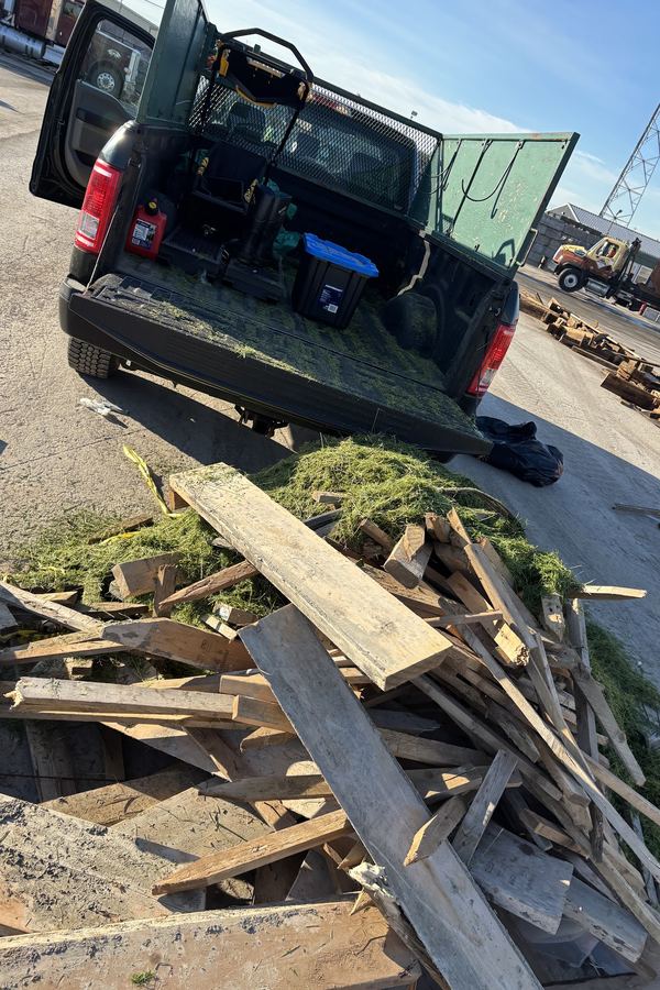 Pile of scrap lumber and grass clippings unloaded beside the truck at the dump